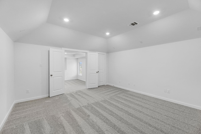 unfurnished bedroom with light colored carpet and lofted ceiling