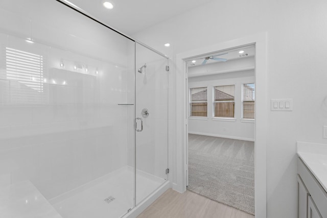 bathroom with ceiling fan, vanity, and walk in shower