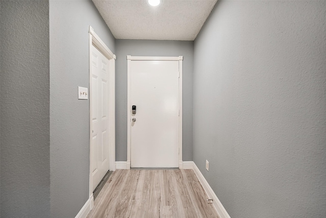 entryway featuring light hardwood / wood-style floors and a textured ceiling