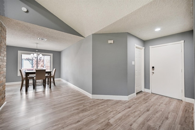 dining space featuring an inviting chandelier, a textured ceiling, and light wood-type flooring