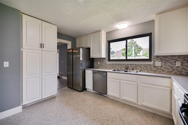 kitchen featuring appliances with stainless steel finishes, sink, white cabinets, and backsplash