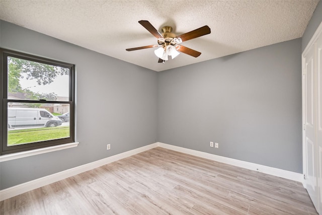 spare room featuring ceiling fan, a textured ceiling, and light wood-type flooring