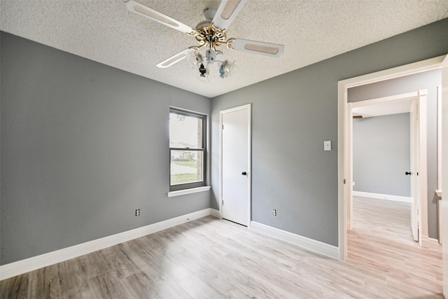 unfurnished bedroom featuring ceiling fan, light hardwood / wood-style floors, and a textured ceiling