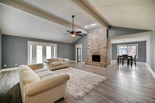 living room featuring hardwood / wood-style floors, a textured ceiling, lofted ceiling with beams, and a brick fireplace