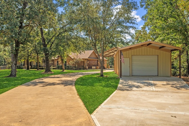 view of front facade with a garage, a front lawn, and an outbuilding