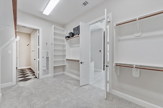 spacious closet featuring light colored carpet