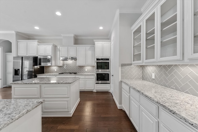 kitchen with a center island, white cabinets, stainless steel appliances, dark hardwood / wood-style flooring, and light stone countertops