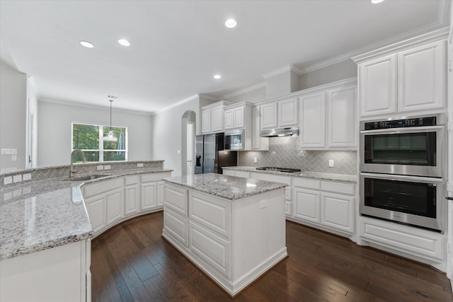 kitchen featuring white cabinetry, appliances with stainless steel finishes, hanging light fixtures, and sink