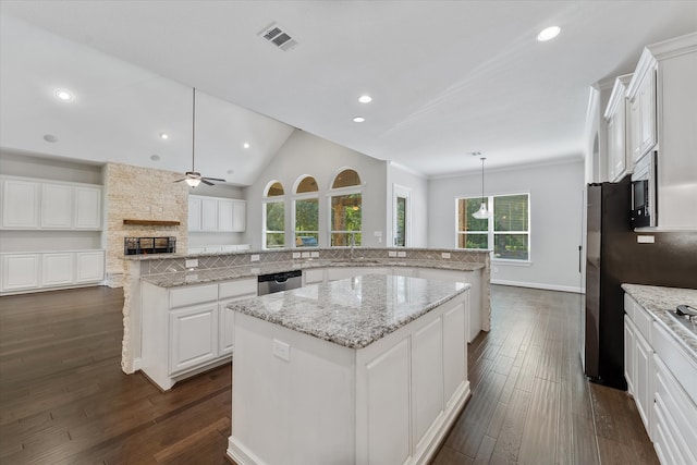 kitchen with vaulted ceiling, ceiling fan, a center island, and a healthy amount of sunlight