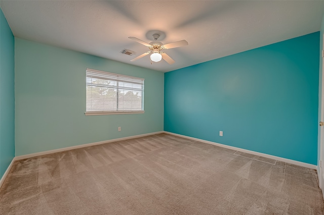 carpeted spare room with ceiling fan