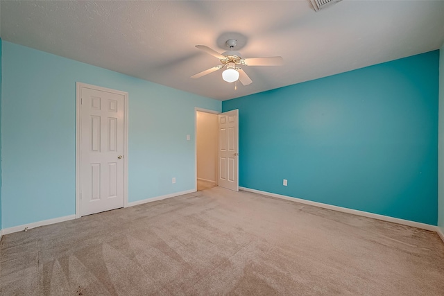 unfurnished bedroom with light carpet, ceiling fan, and baseboards