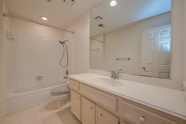 full bathroom featuring tile patterned flooring, toilet, vanity, and tiled shower / bath