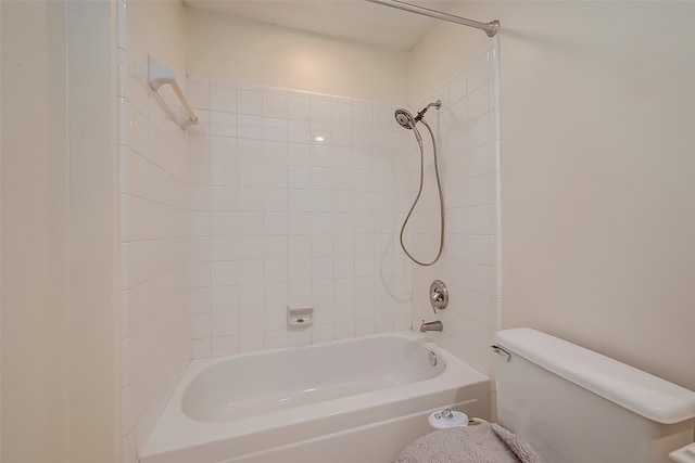 bathroom with toilet and tiled shower / bath