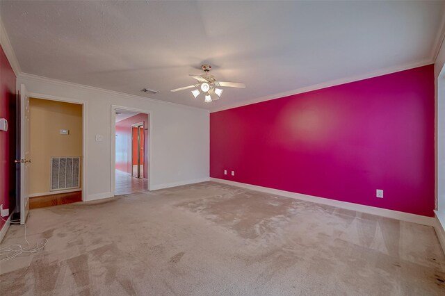 empty room with ornamental molding, carpet, and ceiling fan