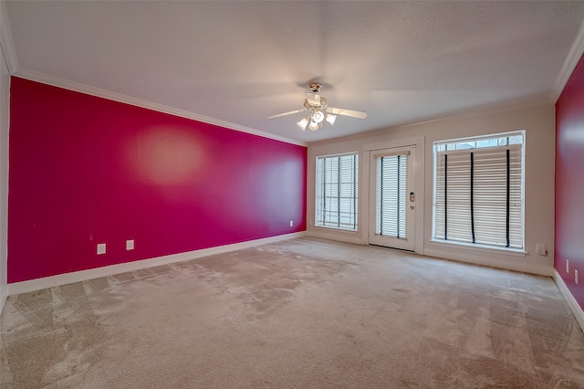 carpeted spare room featuring ornamental molding and ceiling fan