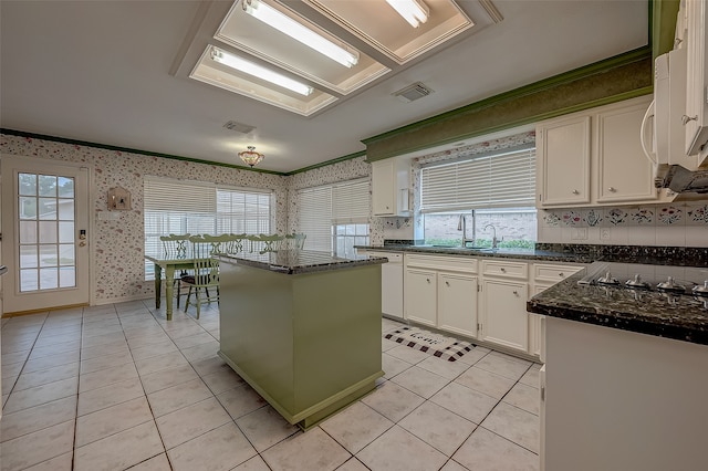 kitchen with sink, white cabinetry, a healthy amount of sunlight, and a kitchen island