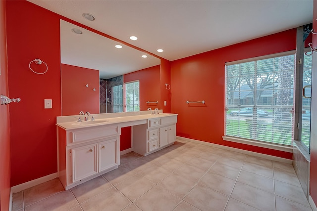 full bath with double vanity, recessed lighting, a sink, and baseboards