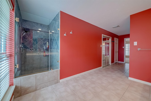 hall featuring visible vents, baseboards, and light tile patterned flooring