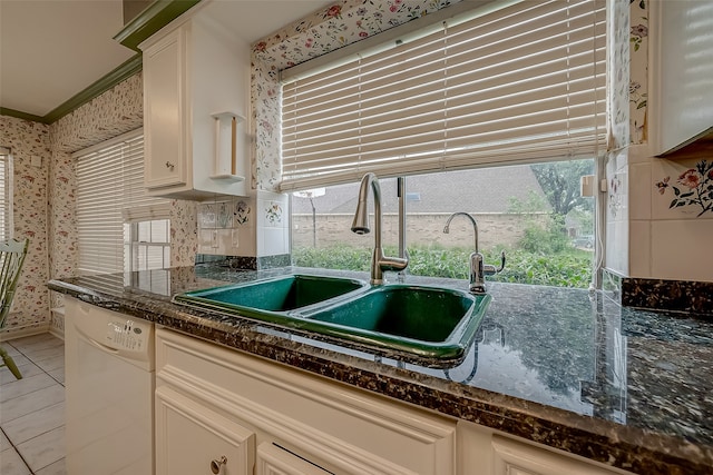 kitchen with white cabinetry, crown molding, sink, dark stone countertops, and white dishwasher