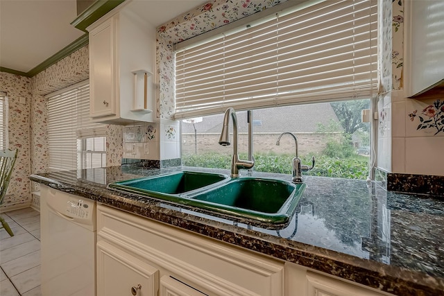 kitchen with light tile patterned floors, decorative backsplash, ornamental molding, a sink, and dishwasher