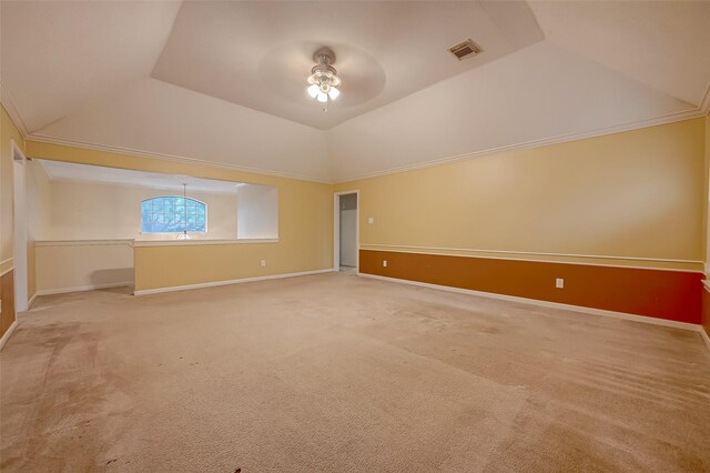 spare room with light carpet, ceiling fan, vaulted ceiling, and crown molding