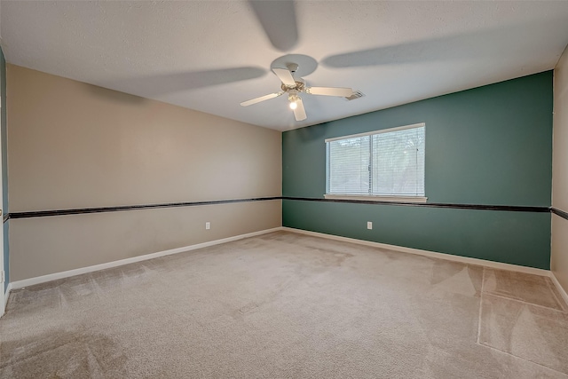 empty room with light colored carpet, visible vents, a textured ceiling, and baseboards