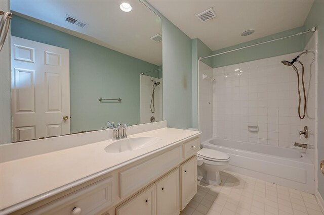 full bathroom with tiled shower / bath combo, tile patterned floors, toilet, and vanity