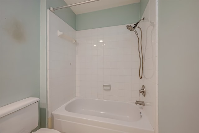 bathroom featuring tiled shower / bath combo and toilet