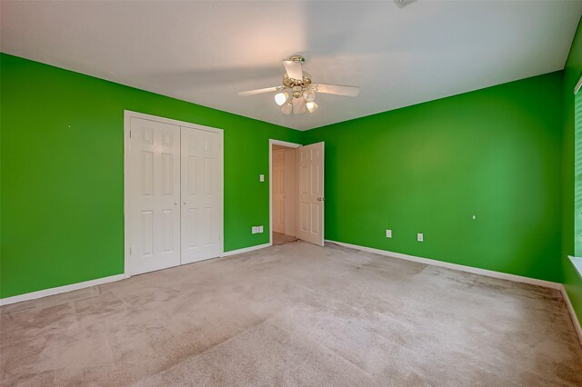 unfurnished bedroom with a closet, ceiling fan, and light colored carpet