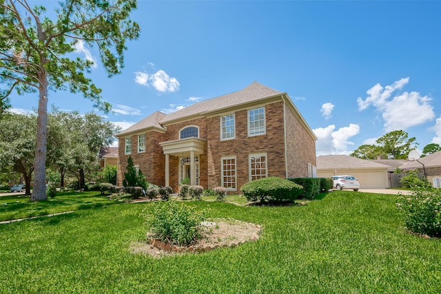 colonial-style house with a garage, a front lawn, and brick siding