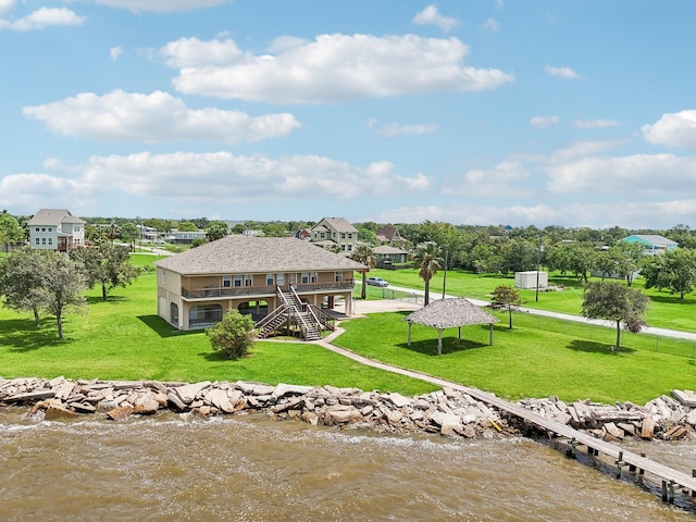 rear view of house featuring a yard and a water view