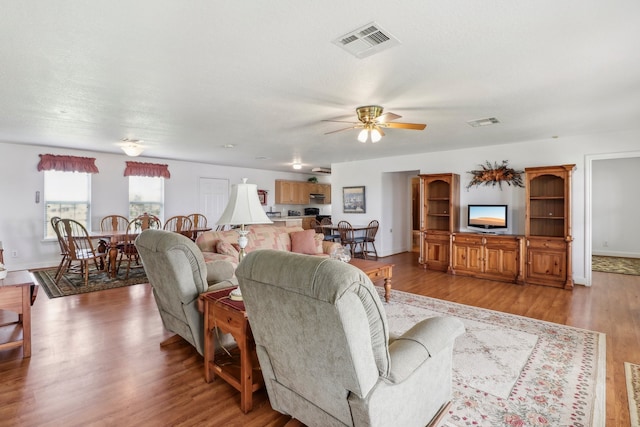 living room with light hardwood / wood-style floors and ceiling fan