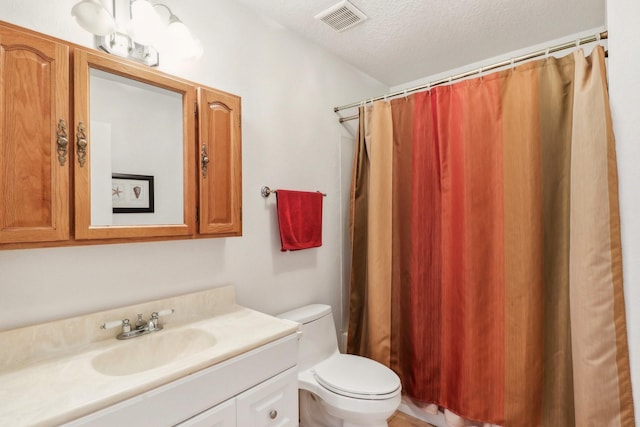 bathroom featuring visible vents, toilet, a shower with curtain, a textured ceiling, and vanity