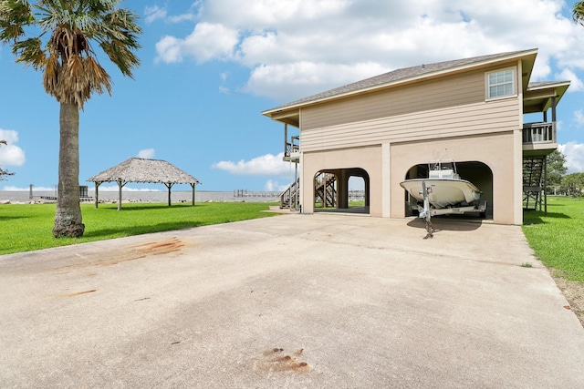 exterior space featuring driveway, stairway, a carport, and a gazebo