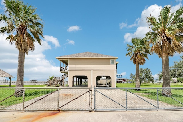 exterior space with a fenced front yard, stairway, a gate, a carport, and stucco siding