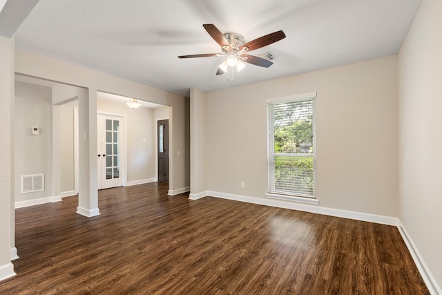 unfurnished room featuring ceiling fan, dark wood-type flooring, visible vents, and baseboards