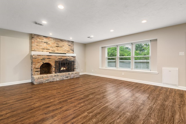 unfurnished living room featuring a fireplace, baseboards, and wood finished floors