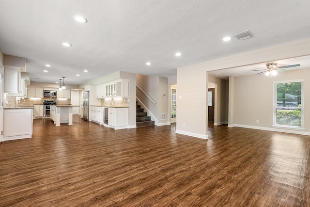 unfurnished living room featuring dark wood-style floors, visible vents, and recessed lighting