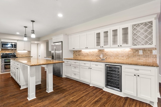 kitchen featuring beverage cooler, stainless steel appliances, dark wood-style floors, and white cabinetry