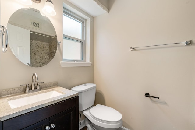 bathroom featuring toilet, baseboards, and vanity