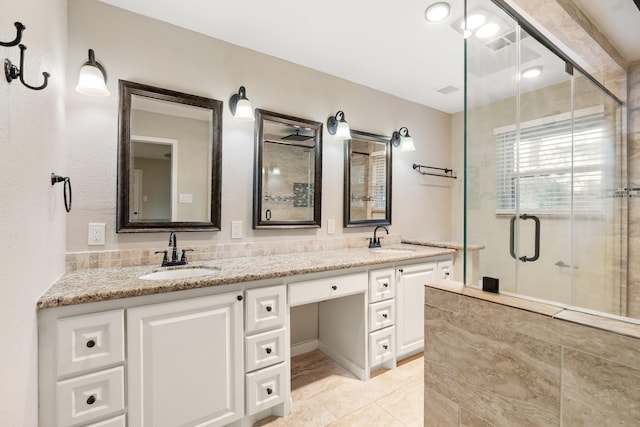 bathroom with double vanity, a stall shower, a sink, and visible vents