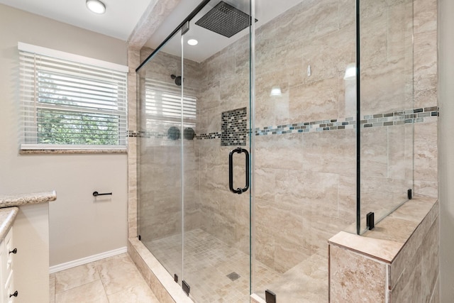 full bath featuring a shower stall and baseboards