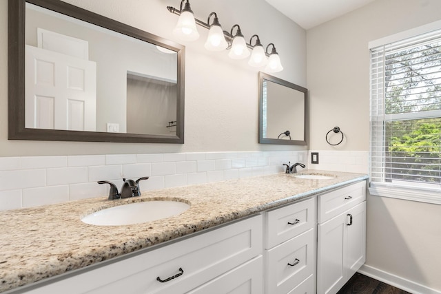 bathroom featuring wood finished floors, a sink, baseboards, and double vanity