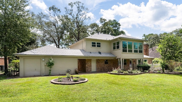 rear view of property with brick siding, a yard, and an attached garage