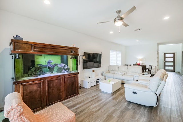 living room with light hardwood / wood-style floors and ceiling fan