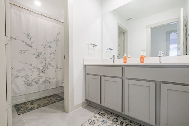 bathroom featuring dual vanity, toilet, and tile patterned flooring