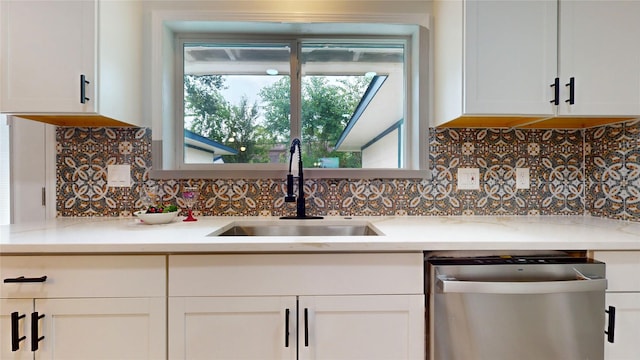 kitchen with stainless steel dishwasher, white cabinets, and sink