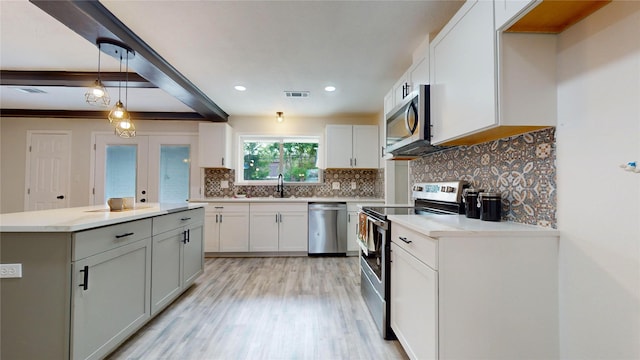 kitchen with white cabinetry, sink, pendant lighting, and appliances with stainless steel finishes