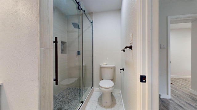 bathroom with toilet and an enclosed shower