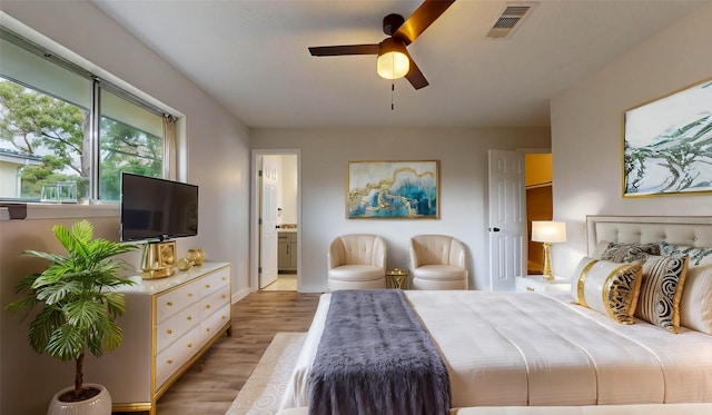 bedroom featuring connected bathroom, light hardwood / wood-style flooring, and ceiling fan